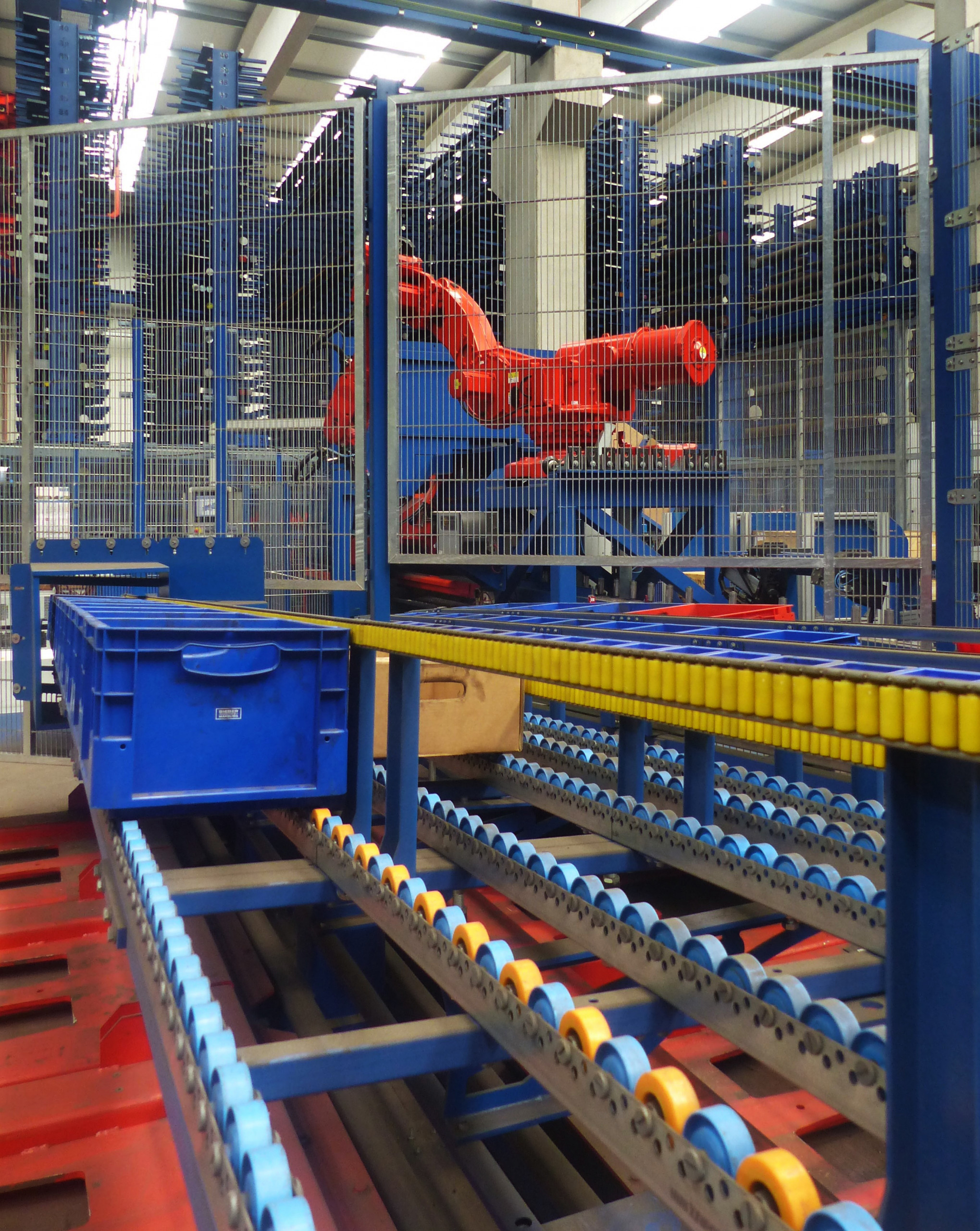 A KASTOsort robot is connected to the fully automatic production circular saw KASTOvariospeed, which takes over the container management: Eight pallet positions on a carousel change automatically, the robot grips the pallets independently and loads them. ©Kasto