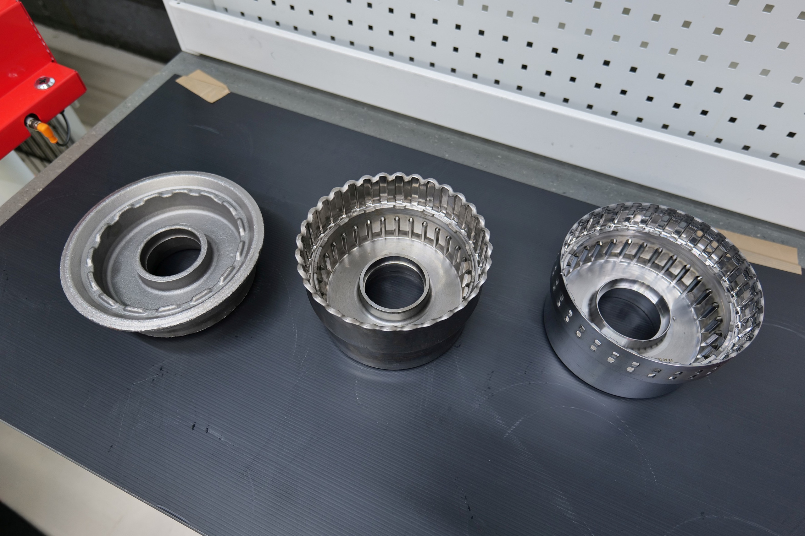 Various wall thicknesses, internal contours and serrations (center) are introduced into the forging blank (left) in the cold forming process by flow-forming and the workpiece is then laser cut. The lamellae carrier (right) can be manufactured in one piece by flow-forming instead of two components to save costs. © Fischer & Kaufmann