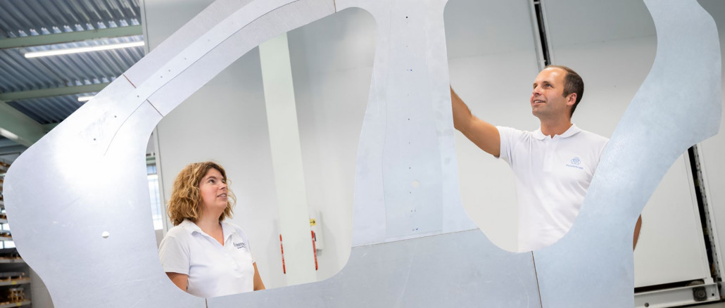 Jana von der Heidt von Baosteel Tailored Blanks und Thomas Böttcher, Leiter Anwendungskonzepte bei Thyssenkrupp Steel, präsentieren den Door Ring: Ein aus einer einzigen Platine maßgeschneiderter Strukturträger für die äußere Seitenwand eines Autos, der bis zu acht Einzelbauteile ersetzt. © Thyssenkrupp Steel