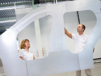 Jana von der Heidt von Baosteel Tailored Blanks und Thomas Böttcher, Leiter Anwendungskonzepte bei Thyssenkrupp Steel, präsentieren den Door Ring: Ein aus einer einzigen Platine maßgeschneiderter Strukturträger für die äußere Seitenwand eines Autos, der bis zu acht Einzelbauteile ersetzt. © Thyssenkrupp Steel