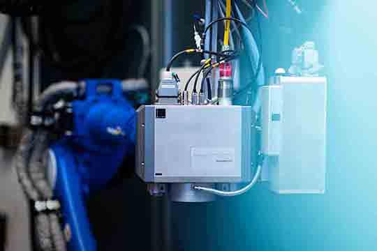 Links ist die Laser-Bearbeitungsoptik zu sehen, rechts das OCT-Messsystem. Beide Systeme können durch eine tiefe Integration aller Komponenten auf Mikrosekunden-Ebene zusammenarbeiten. © Blackbird