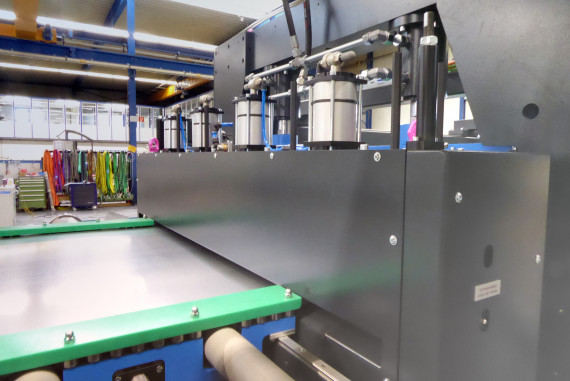 Der Bandeinlauf in den Walzenvorschub: Unter den grünen Abdeckungsstreifen sind die Präzisionskugellager zu sehen, die das einlaufende Blech für die Schere präzise ausrichten. © GSW